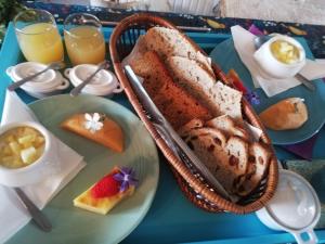 une table avec une assiette de pain et une corbeille de fruits dans l'établissement Le Monticule, à Tardes