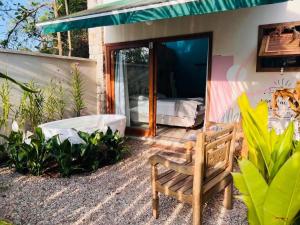 a house with a bench in the yard at Smart Hotel Reserva Ilhabela in Ilhabela