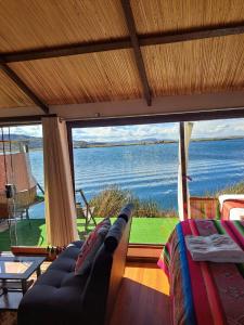 a living room with a couch and a view of the ocean at Uros Aruma-Uro on Uros Floating Islands in Puno
