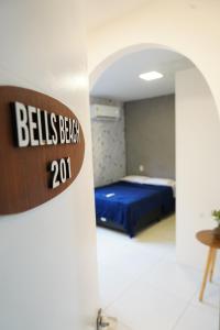 a room with a bed and a sign on a wall at Surf'O Hostel in Rio de Janeiro