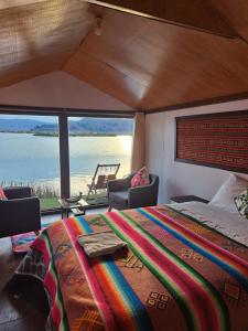 een slaapkamer met een bed en uitzicht op het water bij Uros Aruma-Uro on Uros Floating Islands in Puno