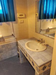 uma casa de banho com um lavatório e um espelho em Bracco Rooms & Suites em Matera
