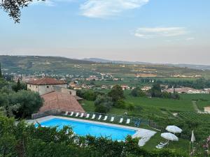 a swimming pool in front of a building with an umbrella at Costa degli Ulivi in Fumane