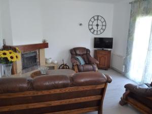 un salon avec un canapé en cuir et une cheminée dans l'établissement Appartement indépendant dans villa, entre Fréjus et St Raphaël, à Fréjus