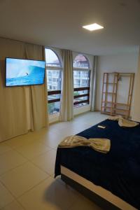 a bedroom with a bed and a flat screen tv at Surf'O Hostel in Rio de Janeiro