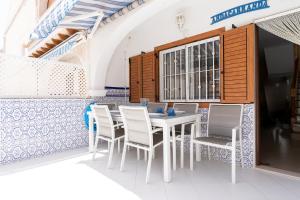 una mesa blanca y sillas en un restaurante en rentafive - Bungaló - Terraza - Parking, en Santa Pola