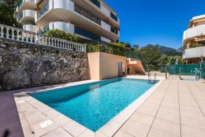 a swimming pool in front of a building at Mon Appart avec Terrasse et Piscine in Roquebrune-Cap-Martin