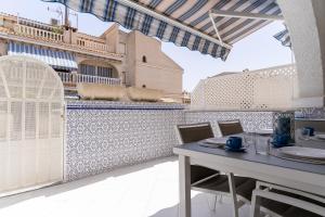 Un patio con mesa y sillas y un edificio. en rentafive - Bungaló - Terraza - Parking, en Santa Pola