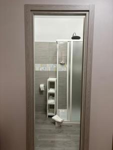 a bathroom with a glass door to a shower with shelves at B&B IL GIRASOLE in Maddaloni