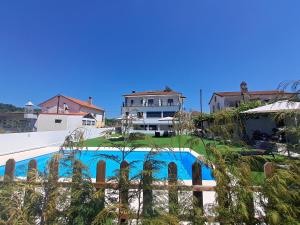 uma vista para uma casa e uma piscina em ArouceHostel em Lousã