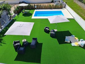 an overhead view of a pool with chairs and umbrellas at ArouceHostel in Lousã