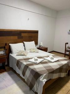 a bedroom with a large bed with two towels on it at Pousada Villa Flamboyant in Beberibe