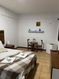 a hotel room with a bed and a table and chairs at Pousada Villa Flamboyant in Beberibe