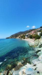 a view of a beach with rocks and the ocean at Ammoudeli Coastal Escape in Plomari