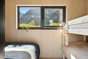 a bedroom with a window and a bunk bed at Luxury Cabin in beautiful Lofoten with Jacuzzi and sauna in Kleppstad