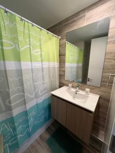 a bathroom with a sink and a shower curtain at Laguna del Mar, Playa Arrecife in La Serena +9 photos