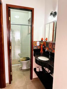 La salle de bains est pourvue d'un lavabo et de toilettes. dans l'établissement Praia Martin de Sá SP., à Caraguatatuba