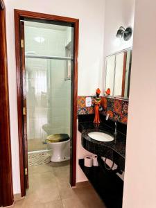 a bathroom with a sink and a toilet at Praia Martin de Sá SP. in Caraguatatuba +20 photos