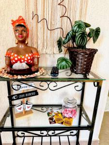 a statue of a woman on a glass shelf with a plant at Praia Martin de Sá SP. in Caraguatatuba