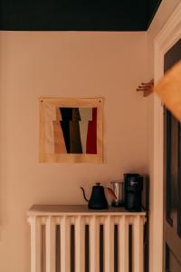 einen Tisch mit einer Kaffeekanne und ein Bild an der Wand in der Unterkunft Somewhere Inn Collingwood in Collingwood