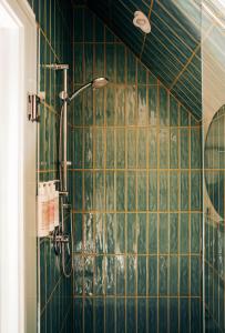 ein Badezimmer mit grünen gefliesten Wänden und einer Dusche in der Unterkunft Somewhere Inn Collingwood in Collingwood