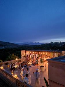 a group of people standing on a balcony at night at Les terrasses du Lac Marrakech in Lalla Takerkoust +97 photos
