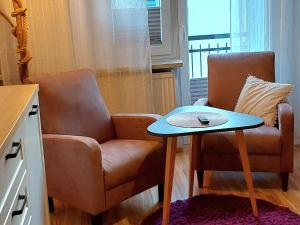 a living room with a chair and a table at Apartamenty i Mieszkania Wakacyjne in Chałupy