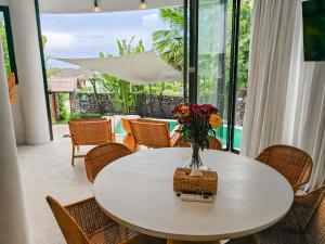 a white table with a vase of flowers on it at Hillstone Luxury Village in Uluwatu