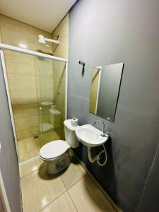 uma casa de banho com um WC, um lavatório e um espelho. em on park hotel e estacionamento traslado em Guarulhos