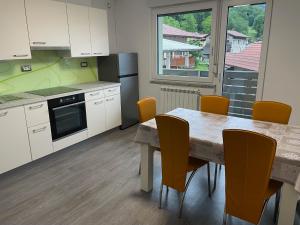 Una cocina con mesa y sillas y una cocina con ventana. en Apartments Valdi, en Tolmin