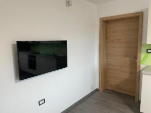 Un televisor de pantalla plana en una pared junto a una puerta. en Apartments Valdi, en Tolmin