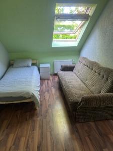 1 dormitorio con cama, sofá y ventana en Kundziņi en Bīriņi