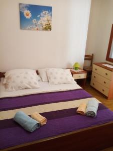 a bedroom with a bed with two pillows on it at Apartments Vitkovic in Cres