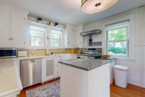 a kitchen with white cabinets and a counter top at Bees Knees House in Boothbay Harbor +16 photos