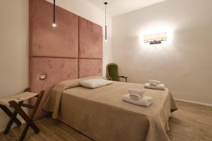 - une chambre avec 2 lits et des serviettes dans l'établissement Makó House - in centro città, à Andria
