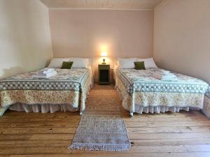 - 2 lits dans une chambre avec une lampe sur une table dans l'établissement The Cornish Inn, à Cornish