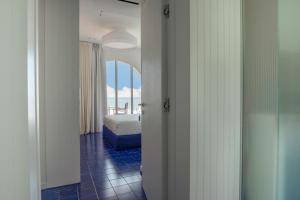 a bedroom with a bed and a view of the ocean at CALEA Boutique Hotel in Bacoli