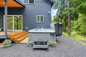 a hot tub sitting outside of a house at Perch - Serenity Nest in Ashford
