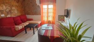 a living room with a red couch and a plant at Apartamento Flor de Luna in Santillana del Mar +9 photos