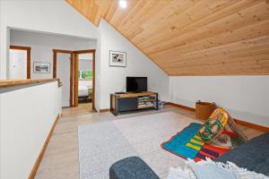a living room with white walls and a wooden ceiling at Perch - Serenity Nest in Ashford