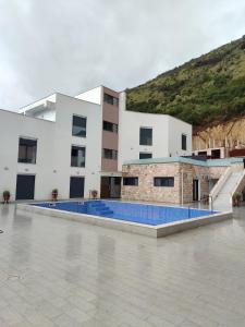 a building with a swimming pool in front of it at Kamara Lux Studio Apartman in Igalo