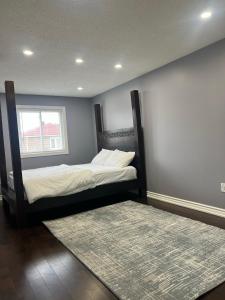 a bedroom with two beds and a rug and a window at Quiet and Contemporary Home in Markham