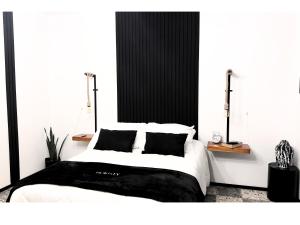 sypialnia z dużym białym łóżkiem z czarnymi poduszkami w obiekcie Homsty w mieście San Martín Texmelucan de Labastida