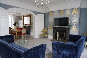 a living room with blue furniture and a fireplace at THE HOE, BEAUTIFUL 5-BEDROOM HOUSE, GARDEN, SECURE PARKING, SLEEPs 12 in Plymouth