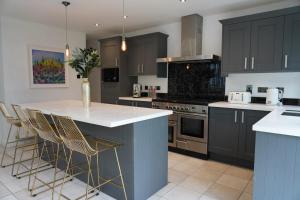 a kitchen with black cabinets and a white counter top at THE HOE, BEAUTIFUL 5-BEDROOM HOUSE, GARDEN, SECURE PARKING, SLEEPs 12 in Plymouth
