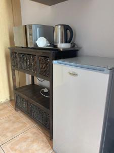 a small kitchen with a refrigerator and a microwave at Sisonke Guest House in Kwamhlanga