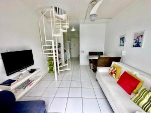 sala de estar con sofá blanco y TV en Angra Inn Praia Grande, en Angra dos Reis