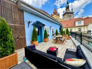 a rooftop patio with a couch and a table at Casa Albastră by Casa Otto in Sighişoara