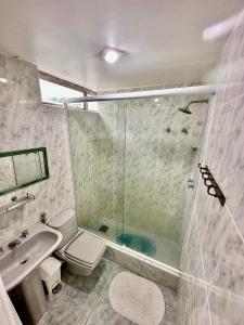 y baño con ducha, aseo y lavamanos. en Angra Inn Praia Grande, en Angra dos Reis