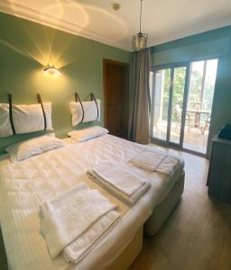 1 dormitorio con 1 cama grande y toallas. en Limon Hotel, en Cesme